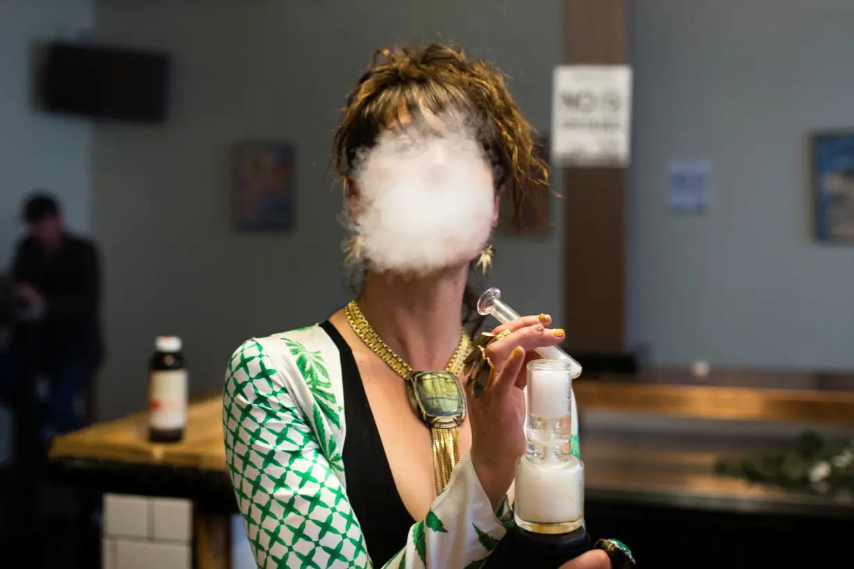 FILE PHOTO: A woman uses a full spectrum oil vaporizer at the Magnolia cannabis vape lounge