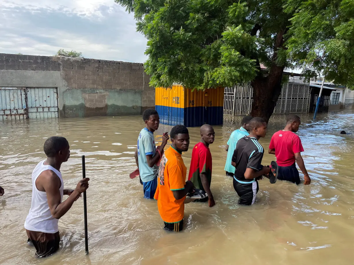 FILE PHOTO: Residents walk in a flooded area during rescue operations in Maiduguri