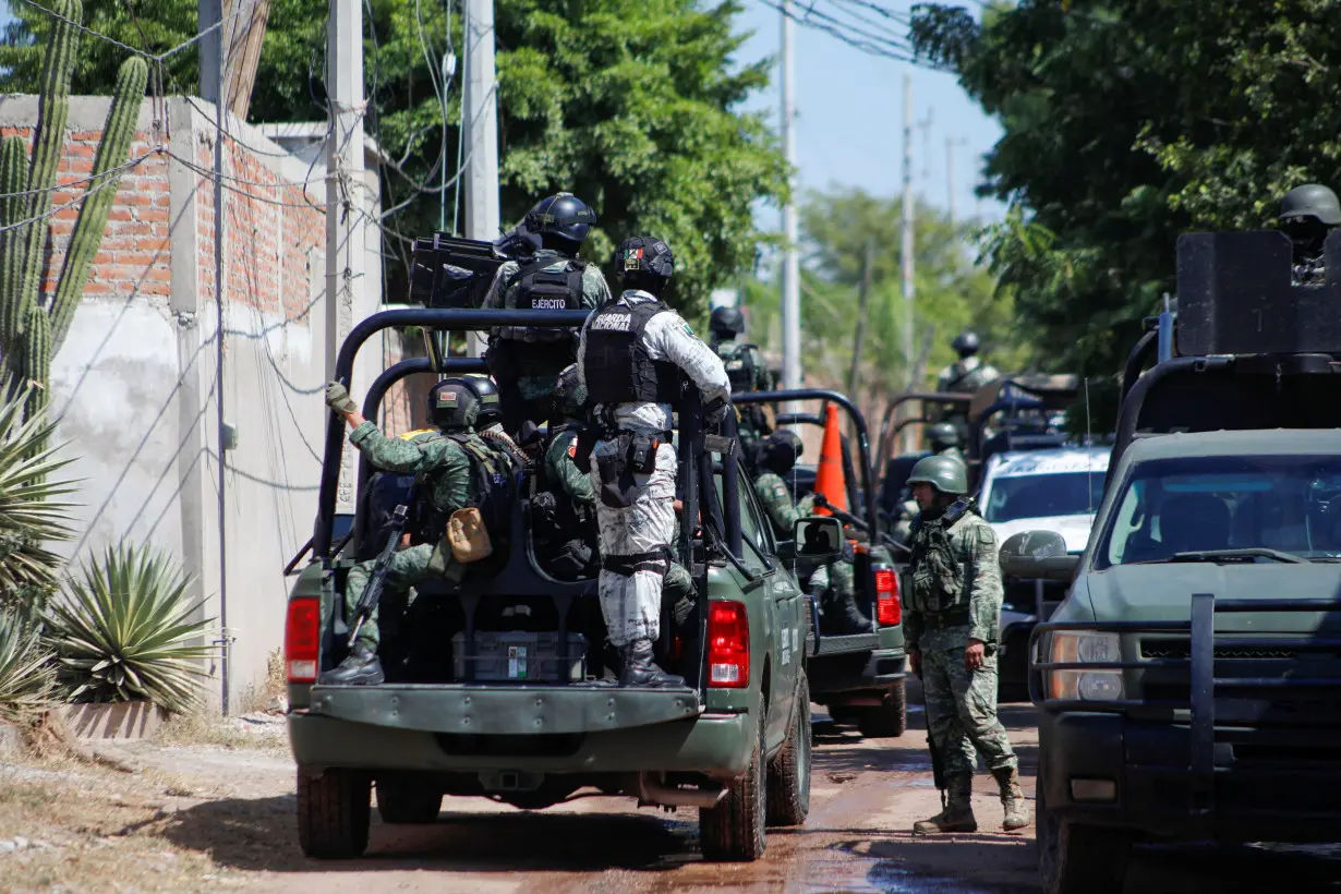 Federal forces guard the perimeter of a scene following a shootout, in Culiacan