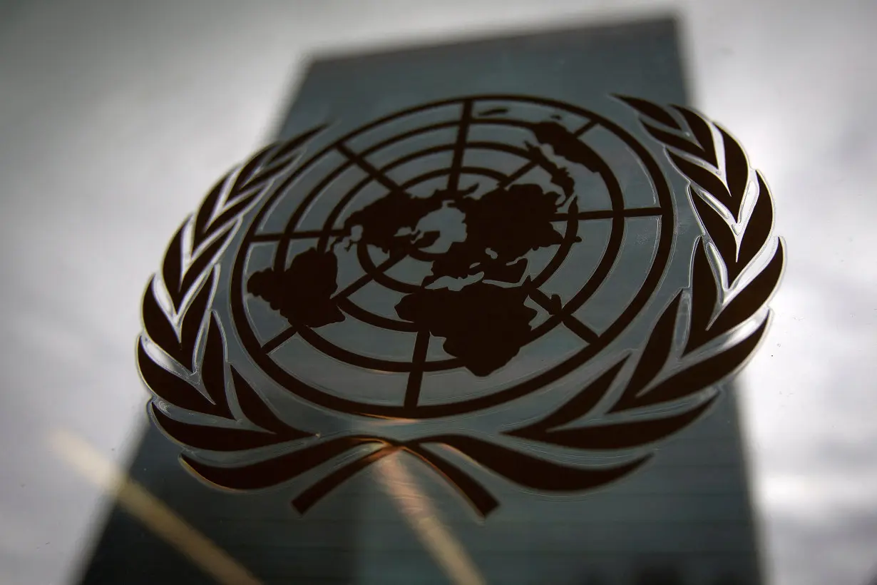 FILE PHOTO: The United Nations headquarters building is pictured though a window with the UN logo in the foreground in the Manhattan borough of New York