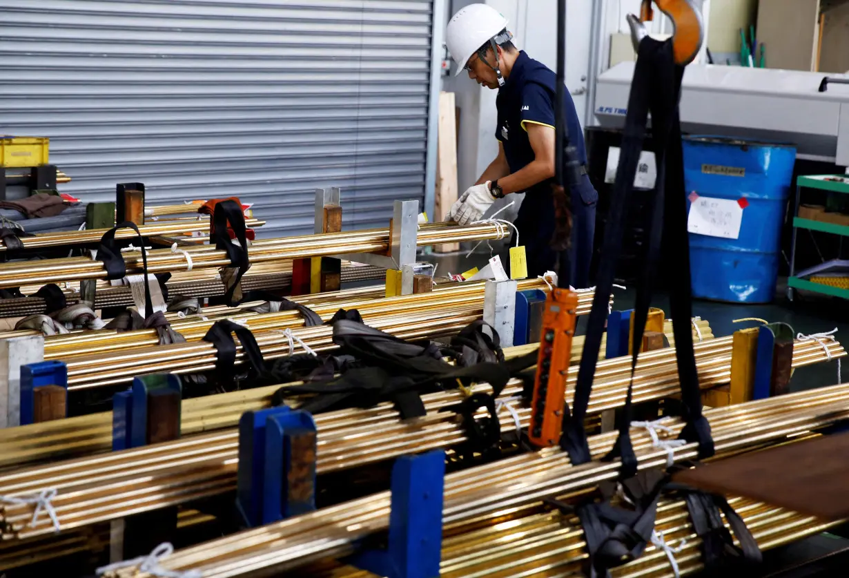 FILE PHOTO: A worker at Sakai Seisakusyo prepares to transport metal rods at its factory in Kakamigahara