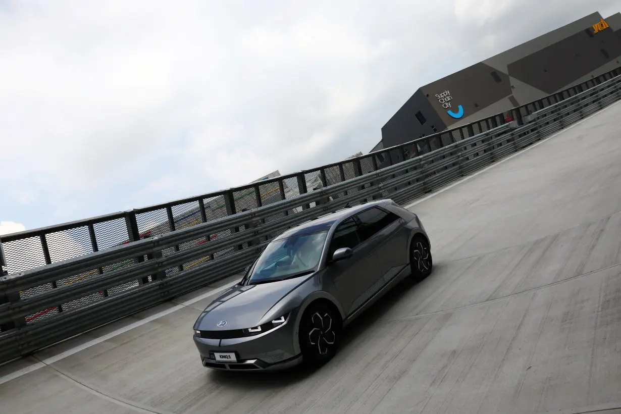 A test driver drives an Ioniq 5 electric vehicle on the rooftop test track of the Hyundai Motor Group Innovation Center Singapore (HMGICS) in Singapore