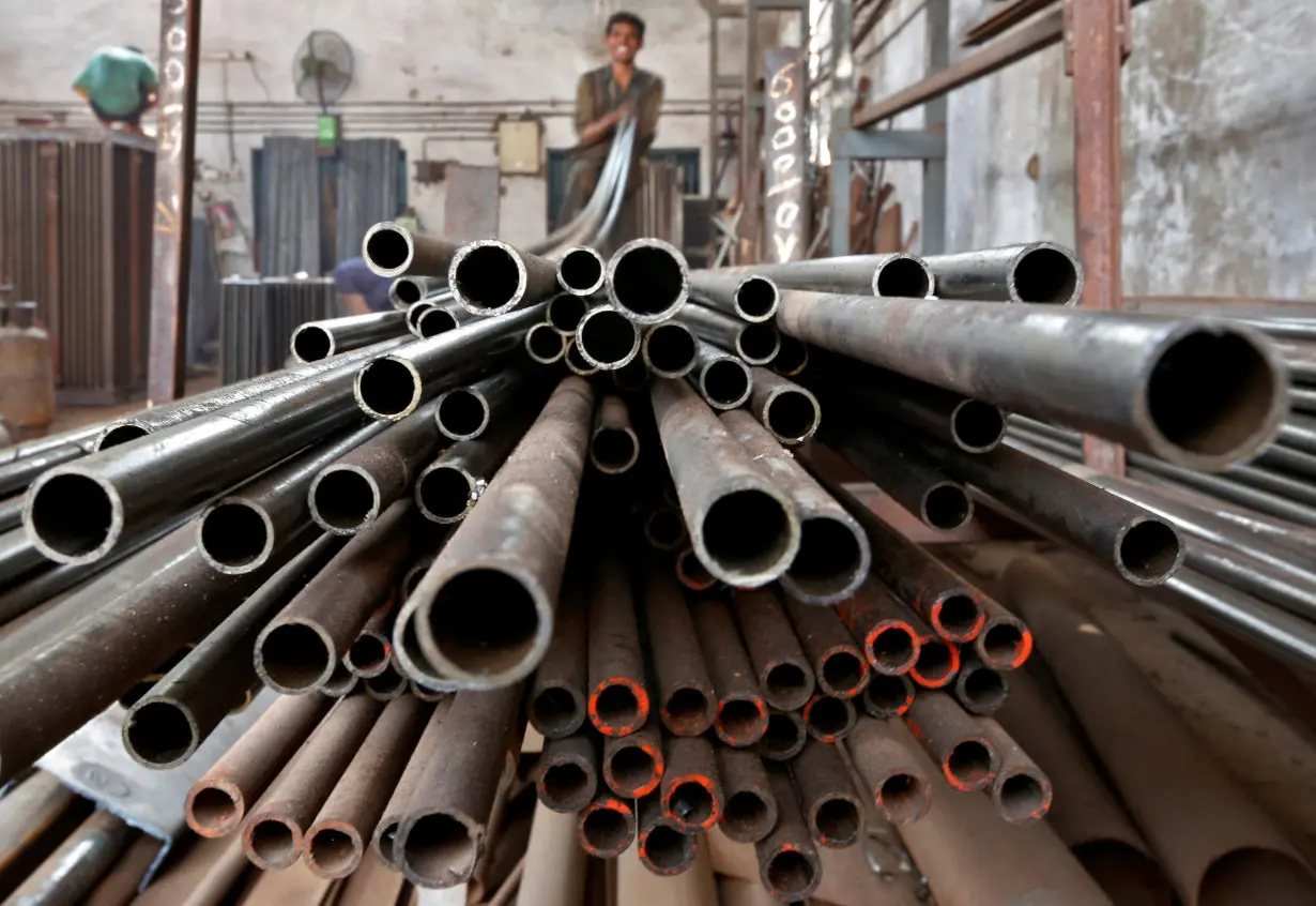 FILE PHOTO: A worker stacks steel pipes in the western Indian city of Ahmedabad