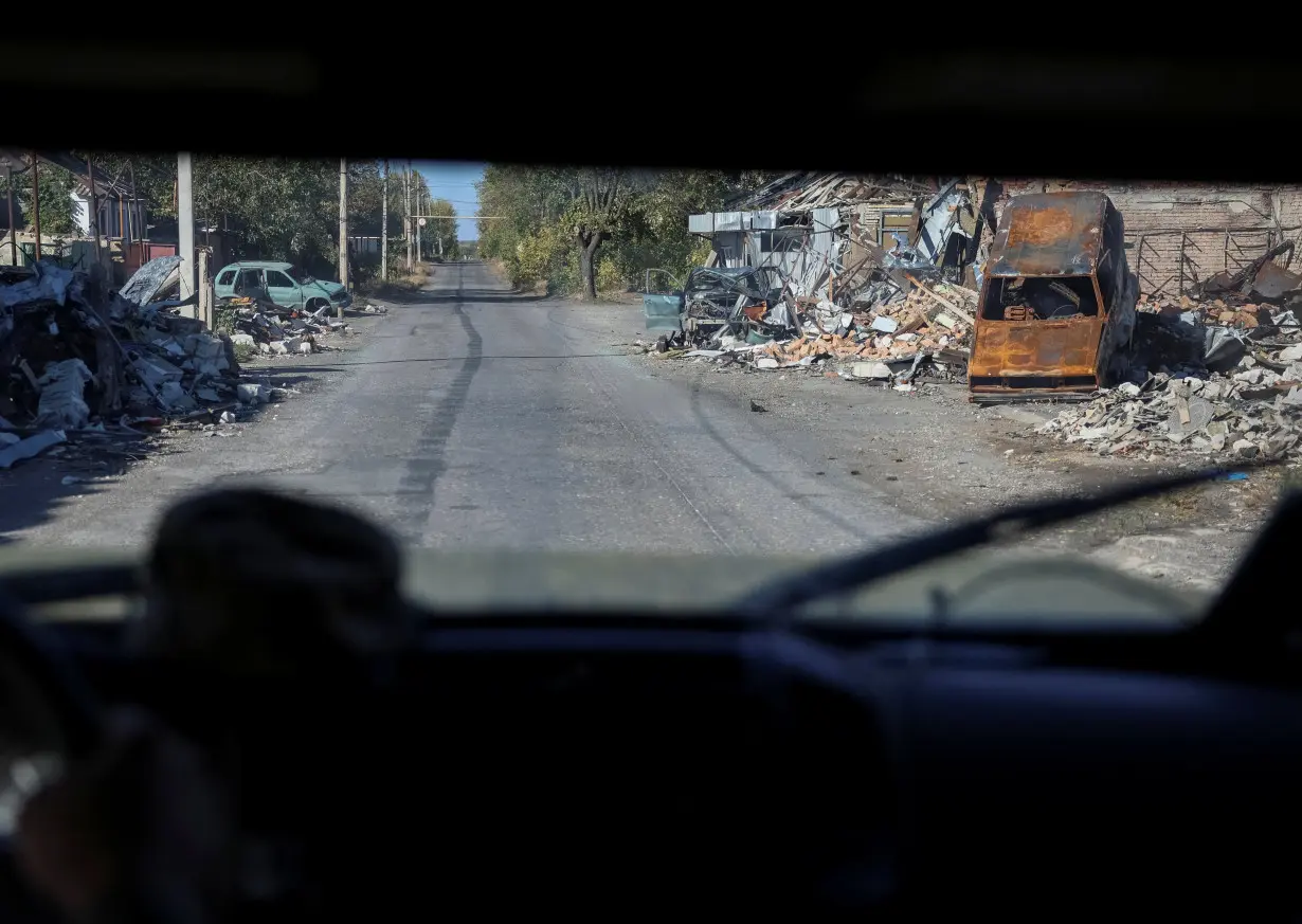 Ukrainian servicemen drive a car in the town of Selydove