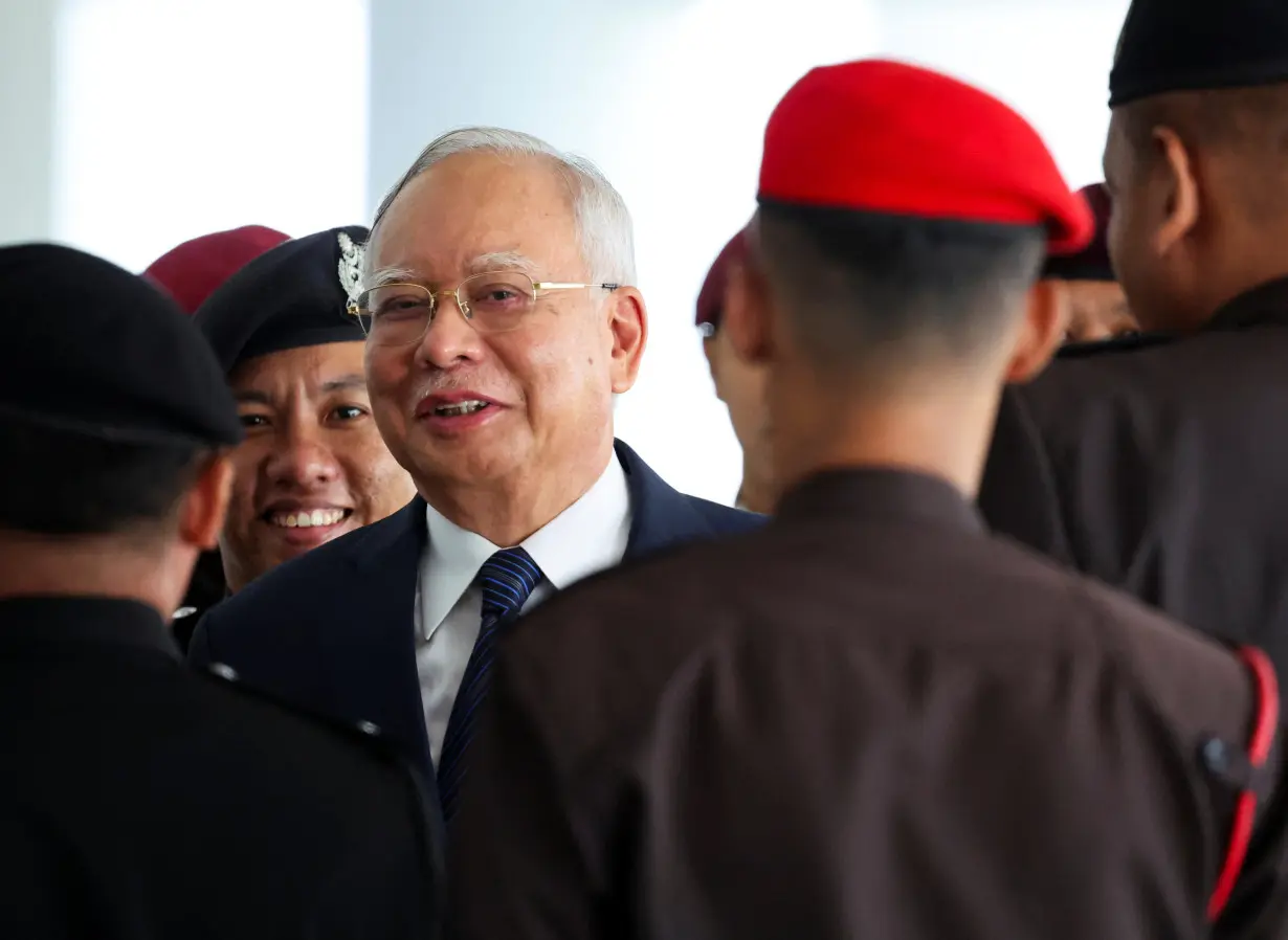 FILE PHOTO: Prison officers escort former Malaysian PM Razak, in Kuala Lumpur