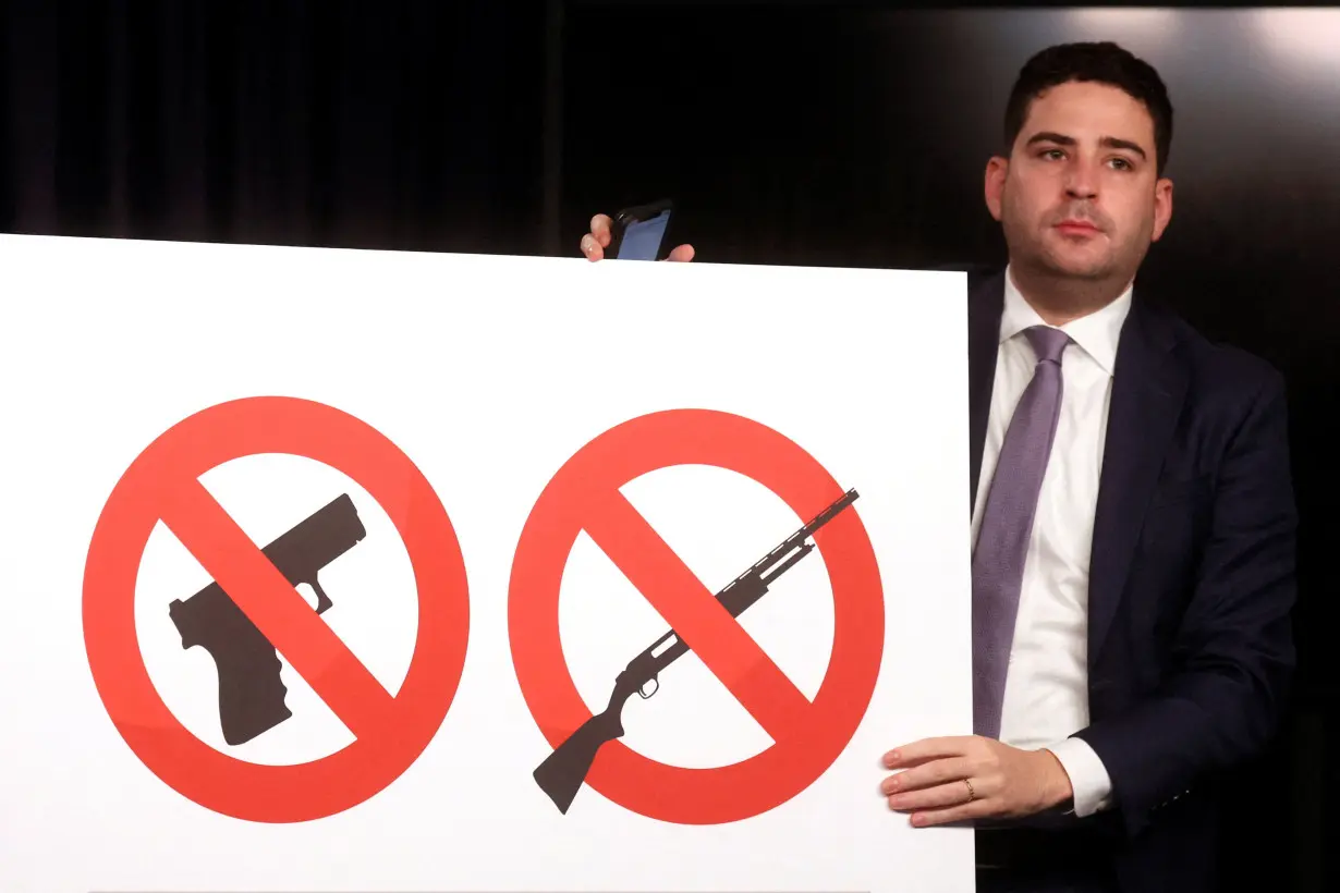 FILE PHOTO: An aide places out a sign similar to what will be posted in a 'gun free zone' prior to a news conference regarding new gun laws in New York