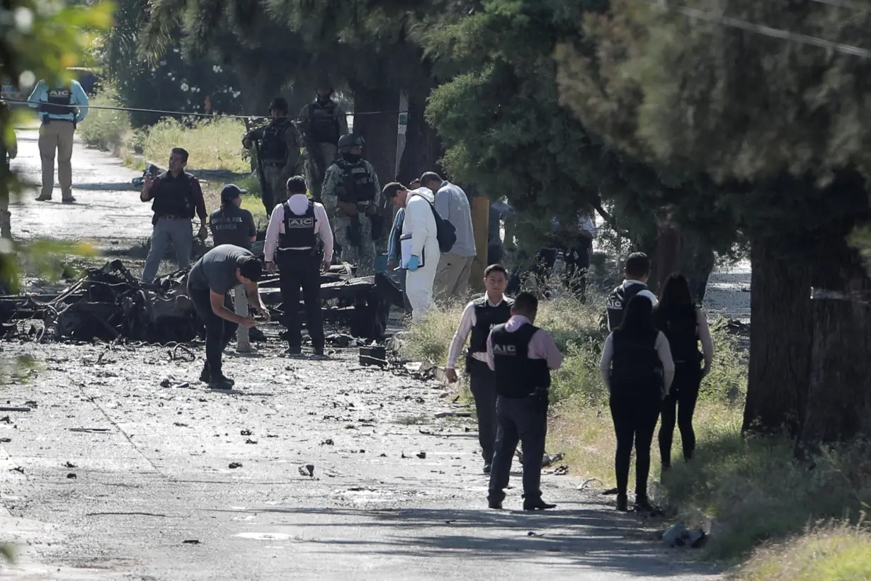 Federal forces work at the scene of a car bomb in Acambaro