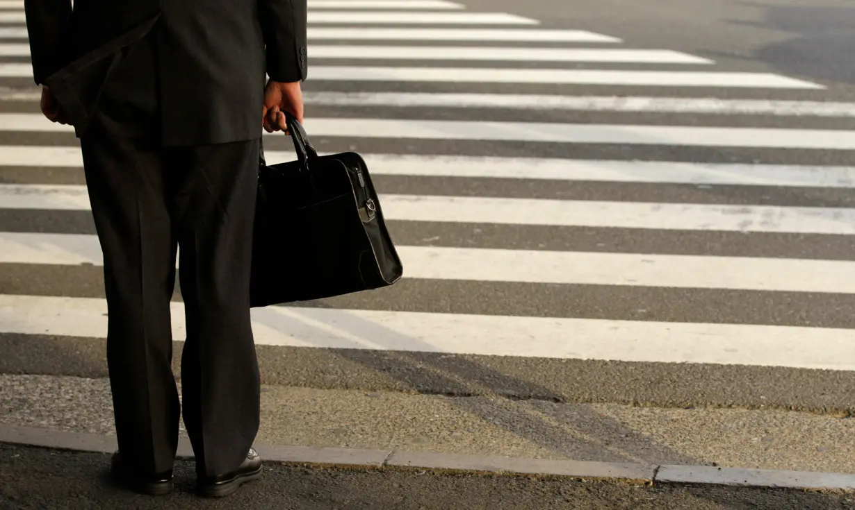 A businessman waits to cross a street in Tokyo