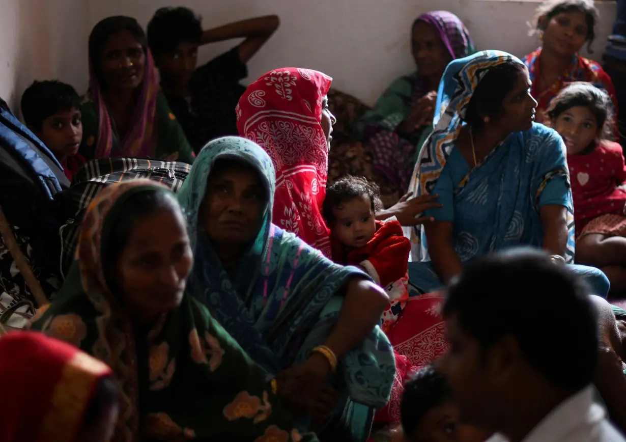 Evacuated villagers sit inside a cyclone shelter near Dhamara fishing harbor in Odisha's Bhadrak district, on Thursday, October 24.