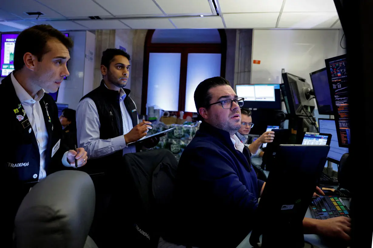 FILE PHOTO: Traders work on the floor of the NYSE in New York