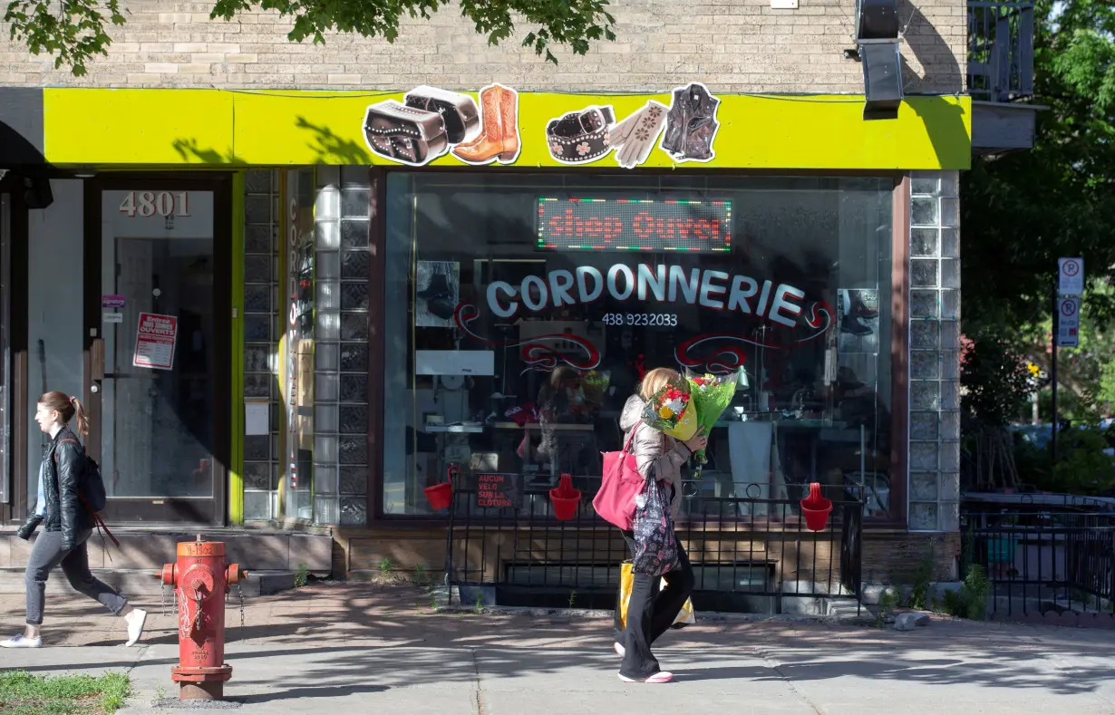 FILE PHOTO: People pass a shop sign written in French in Montreal