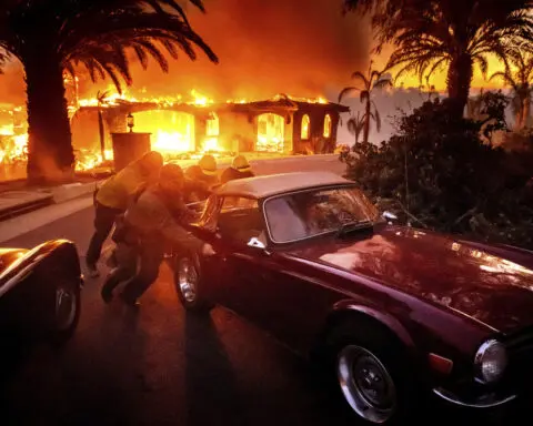 Thousands ordered to evacuate as powerful wind-fed wildfire burns homes in Southern California