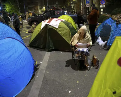 Protesters in Georgia's capital set up a tent camp and demand new elections, wary of Russia