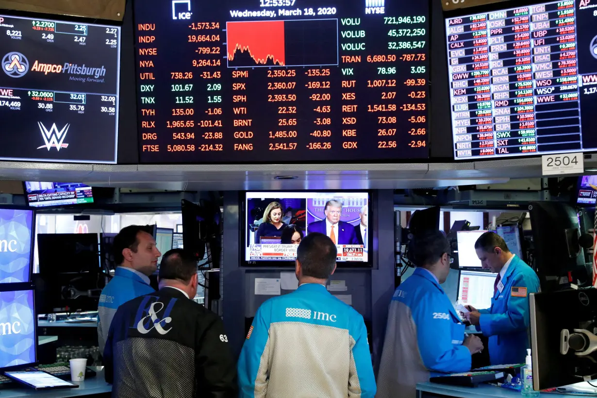 FILE PHOTO: Traders work on the floor of the New York Stock Exchange in New York