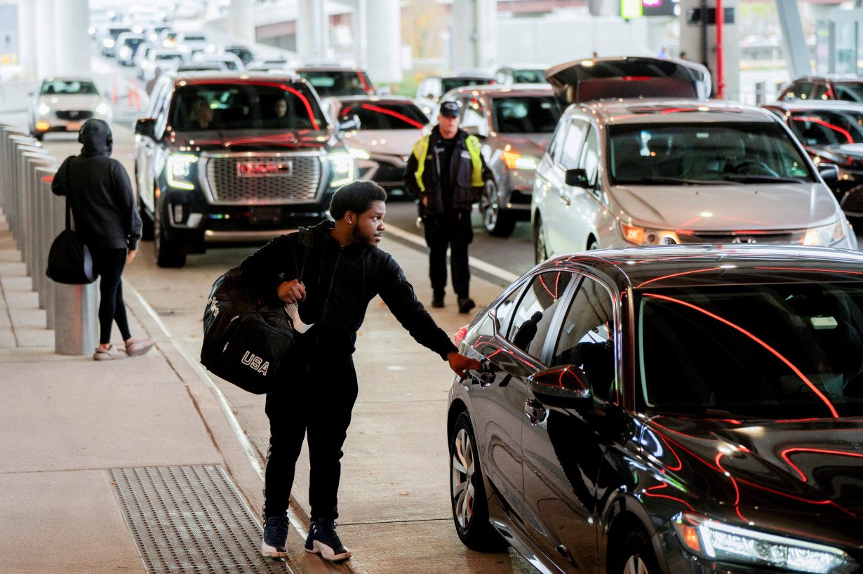 FILE PHOTO: A person opens the door of a vehicle to leave the exit terminal, ahead of the Thanksgiving holiday, at Newark Liberty International Airport in Newark