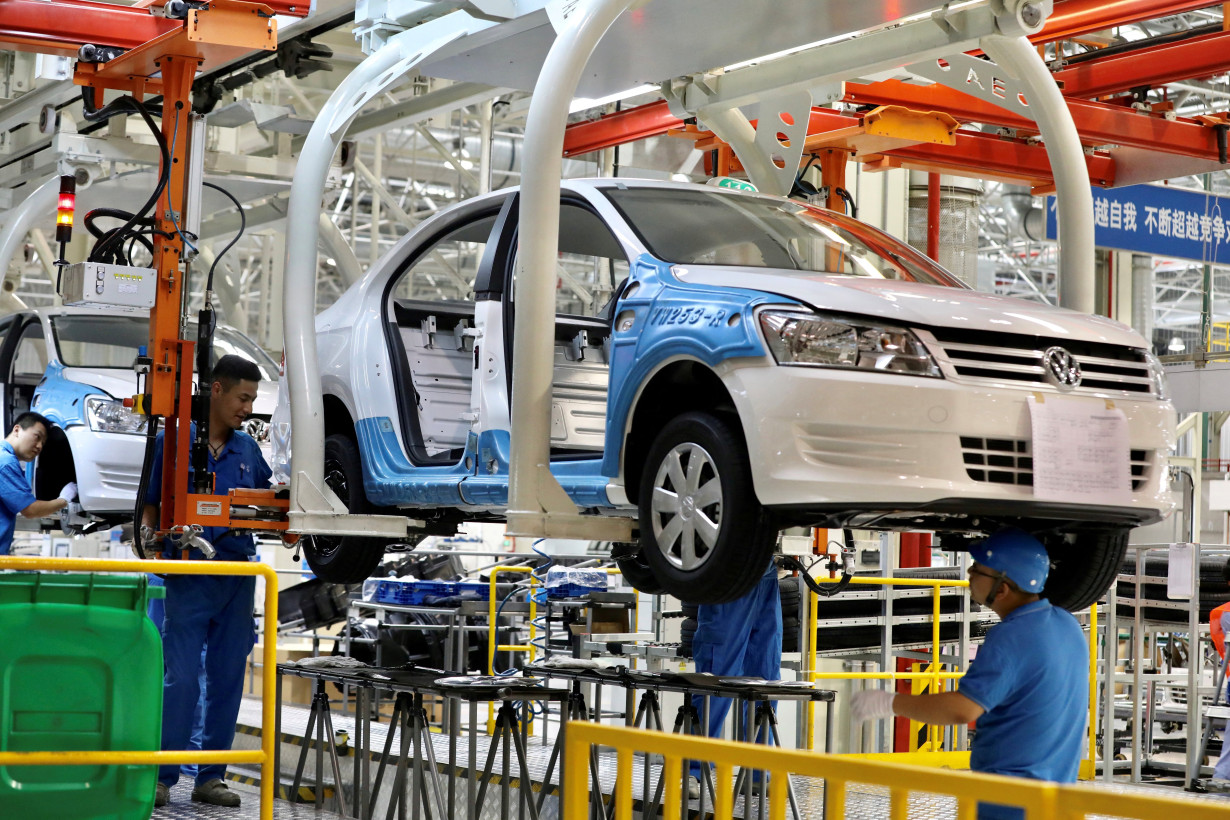 FILE PHOTO: Employees work on assembling vehicles at a plant of SAIC Volkswagen in Urumqi, Xinjiang