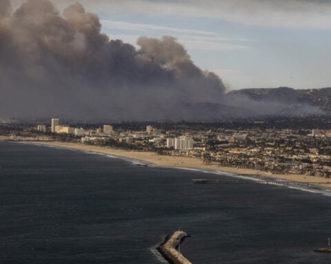 Firefighters battle devastating Los Angeles wildfires as winds calm somewhat