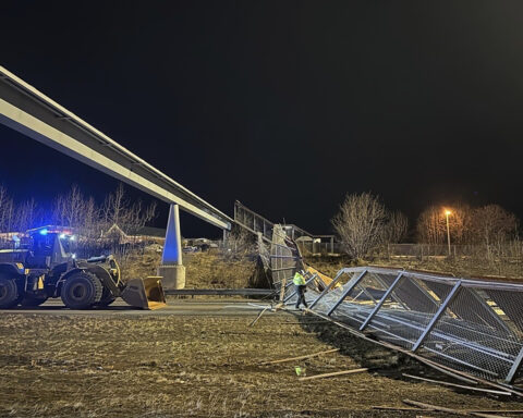 Fencing, roof of Anchorage pedestrian bridge fall in strong wind, closing highway