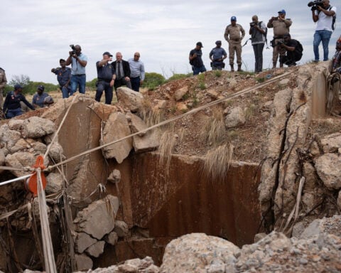 Rescuers try to free men trapped in South African gold mine with scores reported dead