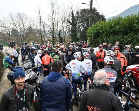 Cycling race upended by riders’ mass protest after cars on the course prompts chaos