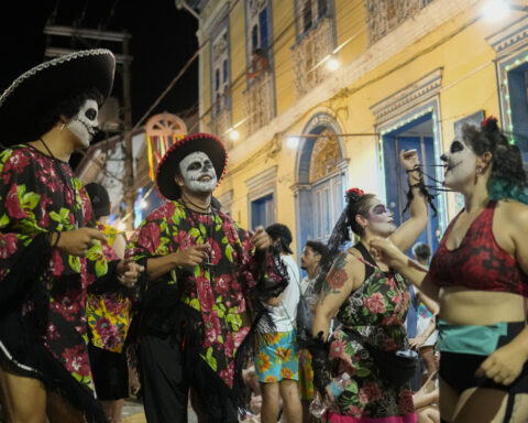 Families and revelers party side-by-side in a traditional Carnival in Sao Paulo's countryside