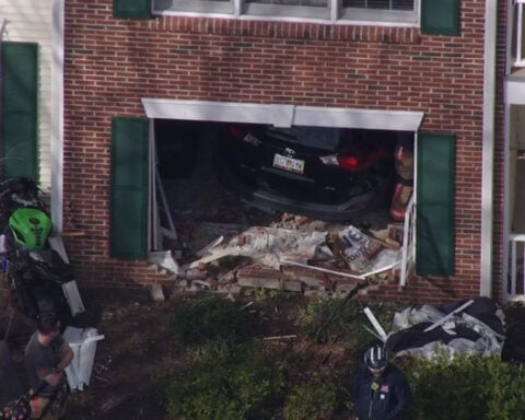 Woman drives SUV into living room of apartment while 2 people inside; no injuries reported