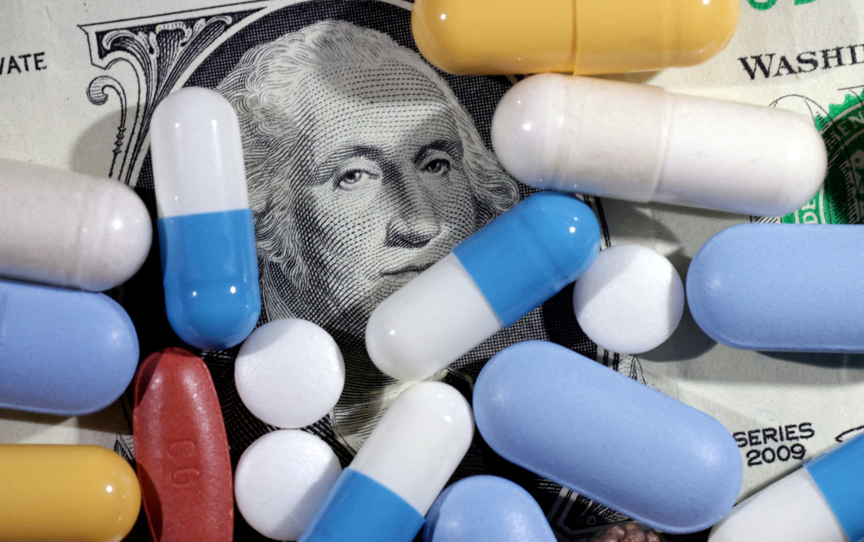 FILE PHOTO: Illustration shows U.S. dollar banknote and medicines