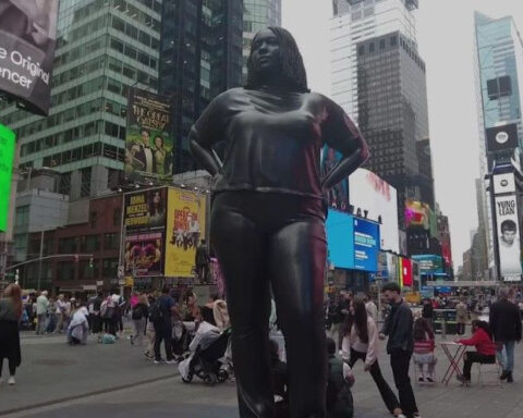 Bronze statue of woman turning heads in busy Times Square