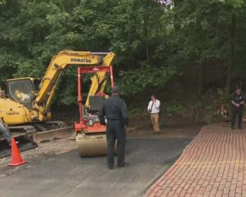 Local representative stands in hole, halting construction project to get city's attention