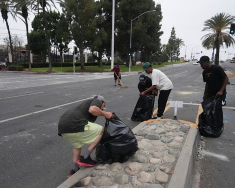 After tear gas and street fires, a Los Angeles community cleans up as National Guard troops arrive