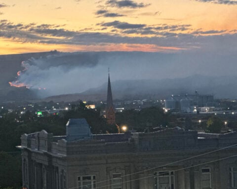 Out-of-control Oregon wildfire forces evacuations and highway closures as gusty winds challenge firefighters