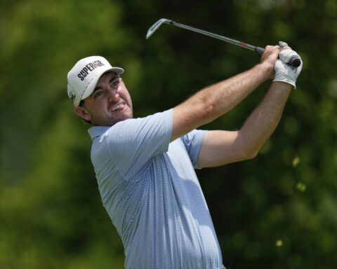 A caddie at heart, Bones Mackay makes sure to get the 18th flag to Spaun's bagman