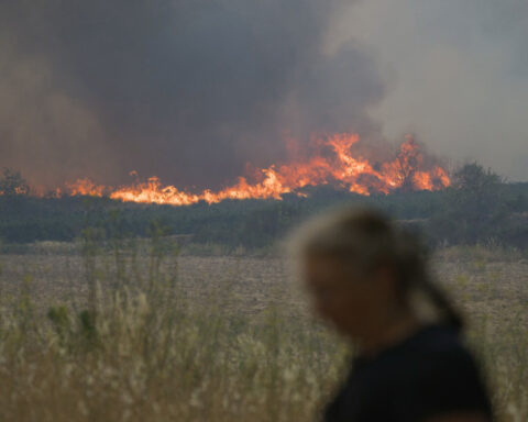 French firefighters battle to contain blaze that killed elderly woman and tore through area bigger than Paris
