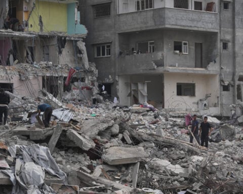 The Latest: Palestinians journey back home as aid convoys enter Gaza and truce holds