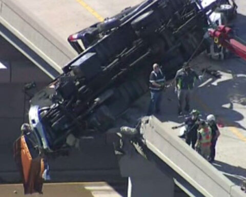 Tow truck dangles off overpass in dramatic crash