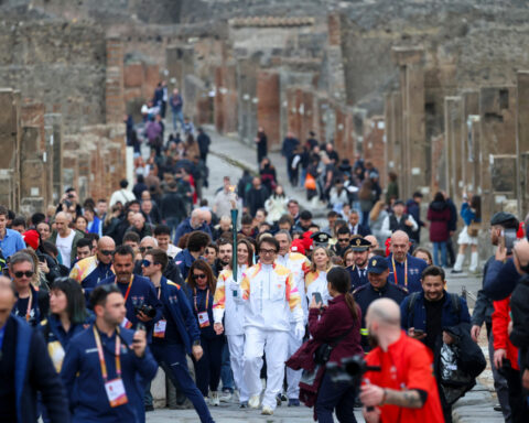 Jackie Chan carries the Milan Cortina Olympic torch through the ruins of Pompeii