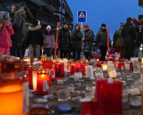 Swiss investigators believe sparkling candles atop wine bottles ignited fatal bar fire