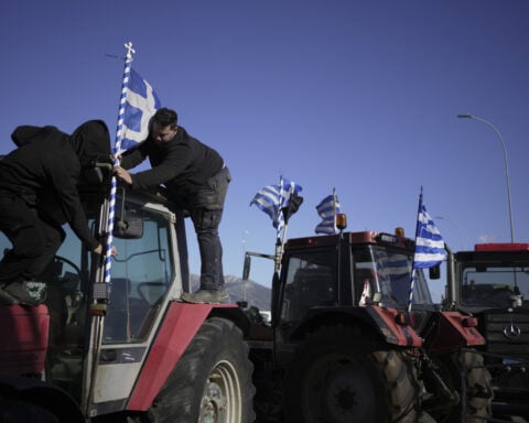 Farmers drive tractors through Paris and block highways in Greece to protest free trade deal