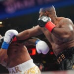 Boxer Jarrell Miller has his hairpiece knocked upward by a punch, then throws it into the crowd