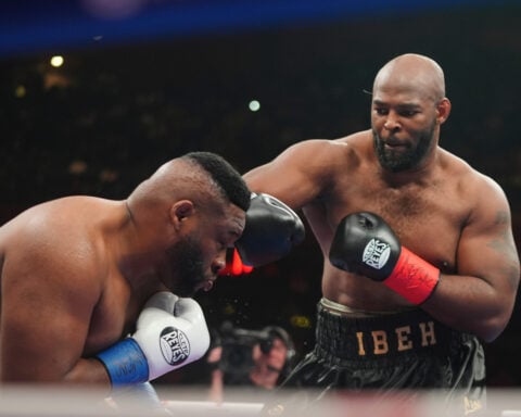 Boxer Jarrell Miller has his hairpiece knocked upward by a punch, then throws it into the crowd