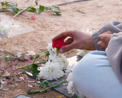 Grieving Iranians cowed into silence beside the graves of protesters