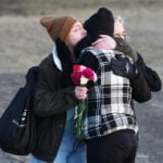 Prime Minister Carney and Canada's main opposition leader hold hands during school shooting vigil
