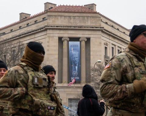Large banner featuring Trump's face is displayed on Justice Department headquarters