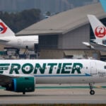 Close call at LAX: Frontier Airlines jet slams on the brakes when two trucks cross its path