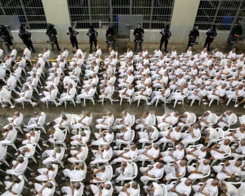 In El Salvador, shackled prisoners watch their mass trial on a big screen