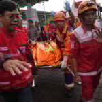 Rescuers trying to reach 3 people trapped in damaged train car after crash in Indonesia