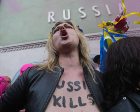 Protesters in pink balaclavas swarm Russia's pavilion at Venice Biennale and release colored smoke