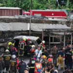 A cargo train hits a public bus at a Bangkok rail crossing, killing at least 8