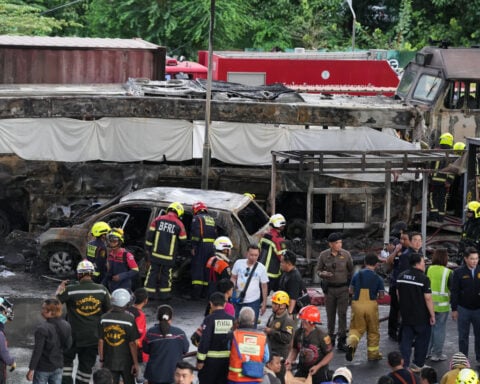 A cargo train hits a public bus at a Bangkok rail crossing, killing at least 8