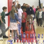 Students create mac-and-cheese domino train before making donation to community